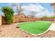 Manicured backyard showcasing artificial grass, desert landscaping, and a private block wall at 16187 W Gibson Ln, Goodyear, AZ 85338