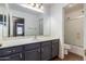 This bathroom features a sleek vanity with gray cabinets and a large mirror over the sink at 16187 W Gibson Ln, Goodyear, AZ 85338