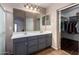 Main bathroom features a dual sink vanity with gray cabinetry and a large mirror at 16187 W Gibson Ln, Goodyear, AZ 85338