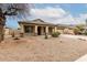 Charming home featuring a two-car garage, covered porch with stone accents, and desert landscaping at 16187 W Gibson Ln, Goodyear, AZ 85338