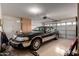 View of a well-lit garage featuring an elegant car, a spacious storage area, and an automatic door at 16187 W Gibson Ln, Goodyear, AZ 85338