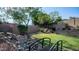 Scenic backyard showcasing a charming bridge over a rock feature, lush green lawn, and mature trees at 1620 W Nighthawk Way, Phoenix, AZ 85045