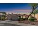 Charming single-story home featuring a three-car garage, desert landscaping, and flag at sunset at 1620 W Nighthawk Way, Phoenix, AZ 85045