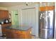 This kitchen includes an island, stainless steel refrigerator, and access to the laundry room at 1624 E Marigold St, Casa Grande, AZ 85122