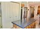 Spacious kitchen boasts an island, stainless steel refrigerator, and ample storage space in white cabinets at 1624 E Marigold St, Casa Grande, AZ 85122
