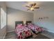 Cozy bedroom with twin beds, a ceiling fan, wood-look flooring, and a window for natural light at 16801 N 94Th St # 1010, Scottsdale, AZ 85260