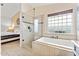 Bright bathroom with a soaking tub, glass shower, and access to the main bedroom at 16823 S 8Th St, Phoenix, AZ 85048