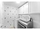 Laundry room featuring a gray front-load washer and dryer, white cabinets, and whimsical cactus wall decor at 16823 S 8Th St, Phoenix, AZ 85048