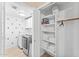 Bright laundry room with white cabinets and cactus wallpaper. Washer, dryer, and organized shelves maximize space and functionality at 16823 S 8Th St, Phoenix, AZ 85048