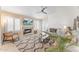 A bright living room featuring a fireplace, plantation shutters, and a ceiling fan at 16823 S 8Th St, Phoenix, AZ 85048