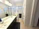 Bathroom featuring double sinks and a tiled shower with glass doors at 172 S Agua Fria Ln, Casa Grande, AZ 85194