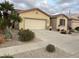 Charming home featuring a desert landscaped front yard, a neutral color palette, and a spacious two car garage at 172 S Agua Fria Ln, Casa Grande, AZ 85194
