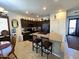 Spacious kitchen featuring dark cabinets, granite countertops, a center island with bar stools, and tile flooring at 172 S Agua Fria Ln, Casa Grande, AZ 85194