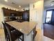 Kitchen island with granite countertop, dark cabinets, bar stool seating and black appliances at 172 S Agua Fria Ln, Casa Grande, AZ 85194