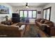 Living room featuring comfortable sofas, a ceiling fan, and large windows with plantation shutters at 172 S Agua Fria Ln, Casa Grande, AZ 85194