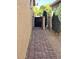 Charming brick walkway leads to a private gate, surrounded by lush landscaping and desert flora at 172 S Agua Fria Ln, Casa Grande, AZ 85194