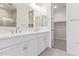 Modern bathroom featuring double sinks, white cabinetry, and a walk-in closet at 18508 E Dario Rd, Gold Canyon, AZ 85118