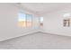 An empty bedroom featuring neutral carpet, several windows providing ample sunlight, and neutral-painted walls at 18508 E Dario Rd, Gold Canyon, AZ 85118