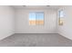 An empty bedroom with neutral carpet, neutral-painted walls, and two windows providing ample sunlight at 18508 E Dario Rd, Gold Canyon, AZ 85118