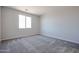 Bright, carpeted bedroom with natural light from a window provides a blank canvas at 19360 N Diego Way, Maricopa, AZ 85138