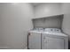 A laundry room featuring a white washer and dryer and a shelf at 19360 N Diego Way, Maricopa, AZ 85138