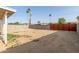 Spacious backyard with dirt area, block wall, and metal gate at 2019 W Wayland Rd, Phoenix, AZ 85041