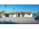 Charming single-story home with a white exterior, brown roof, palm trees, and a block wall in front at 2019 W Wayland Rd, Phoenix, AZ 85041