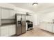 Bright kitchen featuring stainless steel appliances, white cabinetry, tile flooring, and granite counters at 2019 W Wayland Rd, Phoenix, AZ 85041