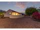 Charming backyard landscaping with a block wall, desert plants, and evening sky at 20301 N Queen Palm Ln, Surprise, AZ 85374