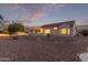 Exterior home view featuring a patio, desert landscaping, and tranquil backyard ambiance at 20301 N Queen Palm Ln, Surprise, AZ 85374