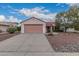 Well-maintained single-Gathering home with desert landscaping, a two-car garage, and mature shade tree at 20301 N Queen Palm Ln, Surprise, AZ 85374