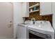 Convenient laundry room features sleek machines and ample storage at 20301 N Queen Palm Ln, Surprise, AZ 85374