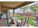 Covered patio with seating area, a fire pit, lush lawn, and landscape at 20583 N Ryans Trl, Maricopa, AZ 85138