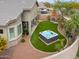 Backyard with a hot tub, an outdoor dining table and artificial grass at 20583 N Ryans Trl, Maricopa, AZ 85138