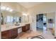 Bright bathroom features dual sinks, a vanity, and a walk-in closet with mirrored doors at 20583 N Ryans Trl, Maricopa, AZ 85138