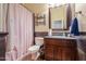 Cozy bathroom featuring a toilet, vanity with storage, and shower with pink curtain at 20583 N Ryans Trl, Maricopa, AZ 85138
