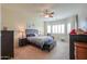 Main bedroom featuring large bed, ceiling fan, and natural light at 20583 N Ryans Trl, Maricopa, AZ 85138