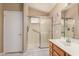 Bright bathroom featuring a glass shower with grab bar, oak vanity, and tiled floors at 21819 N 48Th St, Phoenix, AZ 85054