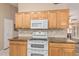 Bright kitchen with granite countertops, wood cabinets, and modern appliances at 21819 N 48Th St, Phoenix, AZ 85054