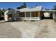 Single story home with boarded up windows, gravel landscaping, and a carport at 2230 N Laurel Ave, Phoenix, AZ 85007
