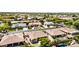 Expansive aerial view showcases a neighborhood with mature landscaping and well-maintained homes with neutral exteriors and tile roofs at 2476 E Marlene Dr, Gilbert, AZ 85296