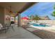 Beautiful backyard featuring a covered patio, pool, and mature palm trees at 2476 E Marlene Dr, Gilbert, AZ 85296