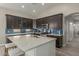 A kitchen is featuring dark cabinetry, a white island with seating, and stainless steel appliances at 2476 E Marlene Dr, Gilbert, AZ 85296