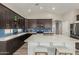 Modern kitchen featuring dark cabinetry, a white island with seating, and stainless steel appliances at 2476 E Marlene Dr, Gilbert, AZ 85296