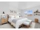 A staged bedroom with soft, neutral colors and decorations has natural light at 2741 E Sweetwater Ave, Phoenix, AZ 85032