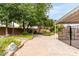 Spacious backyard featuring mature trees, flower beds, stone pathway, and covered patio at 2816 S Don Luis Cir, Mesa, AZ 85202