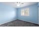 Light-filled bedroom with blue walls, gray carpet, and a bright ceiling fan at 2816 S Don Luis Cir, Mesa, AZ 85202