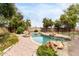 Beautiful pool with rock features, and lush landscaping in a serene backyard setting at 2816 S Don Luis Cir, Mesa, AZ 85202