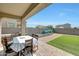 Covered patio leading to a spacious backyard with artificial turf, planter and outdoor seating at 30683 W Amelia Ave, Buckeye, AZ 85396
