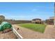 A well-maintained backyard features a manicured lawn, gazebo, and a trampoline at 30683 W Amelia Ave, Buckeye, AZ 85396